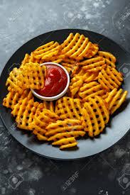 Serve them with sour cream, green scallions, or fried eggs. Crispy Potato Waffles Fries With Ketchup In A Black Plate Stock Photo Picture And Royalty Free Image Image 105755596