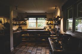 Kitchen & dining room furniture; Interior View Of Kitchen With Stone Tile Floor Wooden Ceiling And Two Sash Windows Antique Wooden Cupboards And Wall Shelves Stockphoto