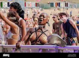 Winchester, UK - 14 Aug 2022, (Editors note image contains nudity)An  attendee in a fancy costume seen singing and dancing at Fair Festival.  Boomtown is a British music festival held every year