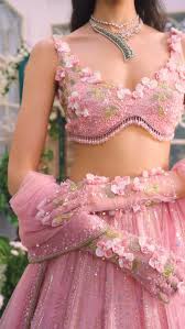 This lehenga is a dreamy pastel pink creation, exuding romance and  elegance. The voluminous skirt is intricately embroidered with delicate 3D  floral appliqués in soft blush tones, each flower adorned ...