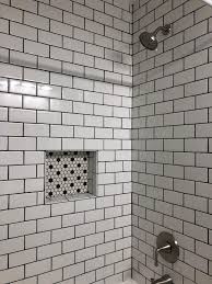 Gray subway tile with black grout. Guest Bath Reno With White Subway Tile Dark Gray Grout Honeycomb Black And White Mosaic Black And White Tiles Bathroom White Tile Shower Black Tile Bathrooms