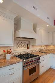This combo brings a contemporary element to the classic log cabin kitchen design. Curved Chimney Range Hood Showplace Wood Cabinets Wolf Range Cultivate Com Hood And Kitchen Cabinets And Countertops Kitchen Remodel Kitchen Remodel Idea
