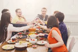 Party, holiday with friends concept. People Clink Glasses Saying Cheers At Party Dinner Table In Cafe Restaurant Or At Home Young Cute Friends Company Celebrate With Organic Food At Wooden Table Indoors Stock Photo Picture And Royalty