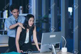Two Young Business People Working Overtime Together Over A Laptop At A Desk  In The Office Stock Photo, Picture and Royalty Free Image. Image 154413912.