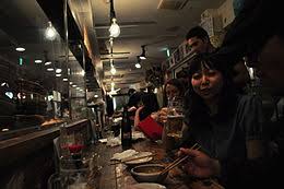 An izakaya (居酒屋) is a type of informal japanese bar that serves alcoholic drinks and snacks. Izakaya Wikipedia