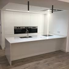 Cocina en blanco laca con isla y dos columnas en la parte frontal. Cocina Blanca Con Isla De Cocina En Silestone Statuario Islas De Cocina Diseno De Cocina Moderna Cocina Blanca Y Madera