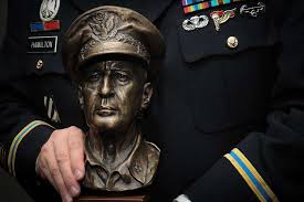 An awardee holds a bust of Gen. Douglas MacArthur during