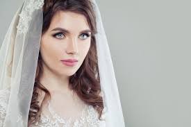 Donna affascinante della sposa con il trucco e il velo su fondo con lo  spazio della copia