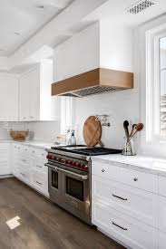 White range hood with wood trim. Kitchen Mixed Shaker And Flat Front Cabinetry With Kitchen 2x10 White Gloss Subway Tile Backsplash An Kitchen Hood Design Kitchen Remodel Small Kitchen Remodel