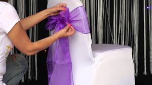 Using ribbons to dress up your wedding chairs, is one of the easiest ways to create a playful or elegant look. How To Various Ways To Tie An Organza Sash To A Chair Cover Youtube