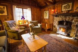 Women wearing socks and pajamas fireplace closeup healthy foods are on the table in the kitchen sitting in front of fire rich lifestyle woman living room interior on rustic wooden table fireplace blurred fresh corner. Adirondack Cabins Chalets Lake Clear Lodge Retreat