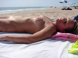 Reife Frau liegt nackt am FKK Strand - Oma Porno Foto