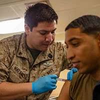 Hospital Corpsman 2nd Class Eric Pacheco administers the H1N1 flu vaccine  to Interior Communications Electrician 2nd Class Stuart Ringrose.