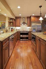 Dark cabinets don't have to be black—if the midnight mood isn't for you, consider a lighter shade of brown. Woods In Warm Rich Medium Brown Tones Were Used To Great Success In This Kitchen Remodel In Wooden Kitchen Cabinets Brown Kitchen Cabinets Warm Kitchen Colors
