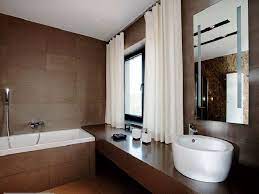 Beige shaker vanity paired with white countertop, frameless mirror, and black sconces. Pin By Jennifer Gonzalez On Furdo Small Bathroom Brown Bathroom Decor Brown Bathroom White Bathroom Decor
