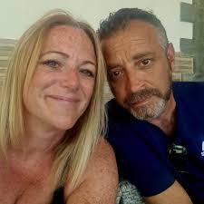 Small dark grey car throwing rocks at parked cars