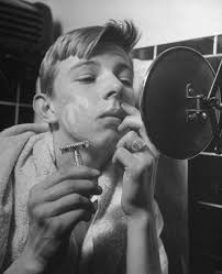 A 17-year-old boy examining the results of his first shave in Des Moines,  Iowa. (1945)