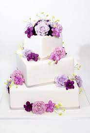 White Fondant Wedding Cake With Square Tiers Decorated With Pink And Purple Roses And Orchids Cake By Car Square Wedding Cakes Fondant Wedding Cakes Cake Boss