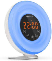 By slowly increasing the level of light in your room, thus mimicking the rising of the sun. Omoton Alarm Clock With Fm Radio And Anti Slip Aluminum Stand Snooze Function Touch Control Wake Up Light Alarm Clock With Sunrise Simulation And Sunset Simulation 6 Nature Sounds Home Kitchen Wake Up Lights
