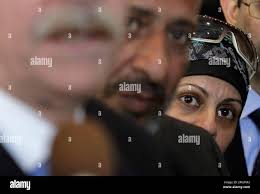 Mona Daoud, right, peers over her husband Ahmed's shoulder as their  attorney Thomas Durkin, left, responds to a question about their son, Adel  Daoud, in the federal courthouse lobby Thursday, Oct. 11,
