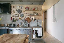 キッチンカウンターの下に業務用の冷蔵庫を収納 コンロは三口の ガスクッカー 廊下は一段高いosb合板と天井にシナ合板 キッチンとリビングはモルタル仕上げにして 空間をゆるやかに分けている 合板キッチン リビング キッチン インテリア