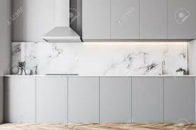 For this classic style kitchen, since the cabinetry uses a combination of flat white and cool gray cabinets, as well as white marble countertops, the floors used beige marble tiles to give the space a subtle warm tone, creating a more balanced look. White Marble Kitchen Interior With Light Gray Countertops And Stock Photo Picture And Royalty Free Image Image 101817944