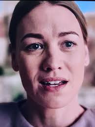 What is the significance of the character's one filled-in eyebrow in The  Handmaid's Tale?