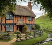 Thatched roof cottages with flowers surrounding them