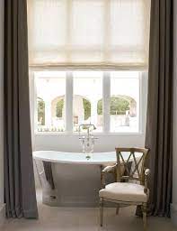 The space surrounding the freestanding tub makes the room feel more open, as does the lightweight curtain fabric, which allows maximum. Freestanding Modern Cast Iron Bathtub Designed Under A Bathroom Window With Gray Privacy Curtains Pair Interior Design Marble Herringbone Tile Privacy Curtains