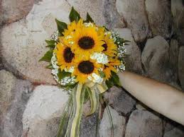 Beautiful white wedding cake with floral decor displayed on a wooden slice. Sunflower In Season Summer Color Yellow Cost Inexpensive Moderate Sunflower Bouquets Sunflower Bridal Bouquet Wedding Flowers Summer