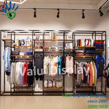 Freestanding racks include features like adjustable shelves, detachable hook brackets for handbags or extra pieces of clothing and collapsibility for convenient storage. China Free Standing Metal Wood Display Stand With Hanging Rack For Clothes Retail Shop Design China Cloth Rack Steel Stand And Clothes Stand Fixture Price