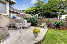 A concrete patio can be an unimportant addition to a home's property or nothing short of an awesome entertaining space, depending on one's creative insight and eye for. Backyard Patio Area With Table Set And Umbrella Patio With Concrete Stock Photo Picture And Royalty Free Image Image 32041130
