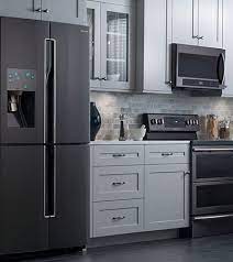 This kitchen features grey perimeter cabinetry (with amazing chef's kitchen style appliances), and charcoal grey with stainless lighting and hardware and patterned grey stone counters give this grey stained wood cabinets look super modern and the black and wood shelving along with the wood. Related Image Kitchen Cabinet Remodel Kitchen Plans Black Appliances Kitchen