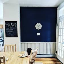 Navy Blue Accent Wall In Farmhouse Kitchen With Concrete Clock Paired With Grey Wainscoting And White Walls Parq Blue Accent Walls White Walls Kitchen Themes
