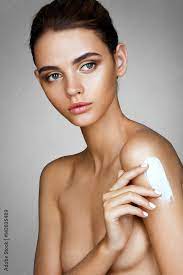 Tanned girl nude topless apply the moisturizer cream touching. Photo of  beautiful young girl with perfect skin. Skin care concept фотография Stock  | Adobe Stock