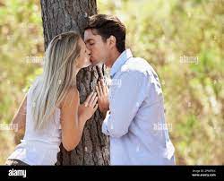 Caught up in the romance. A beautiful young couple showing their affection  in the park Stock Photo - Alamy