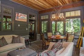 A stylish vintage rustic sunroom with wooden furniture, floral and other print textiles, potted blooms and greenery. Timeless Allure 30 Cozy And Creative Rustic Sunrooms