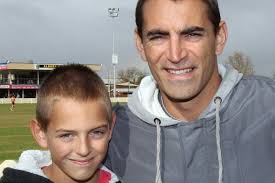 Bailey McAlister presented with his Osborne jumper by father and  premiership coach Daniel