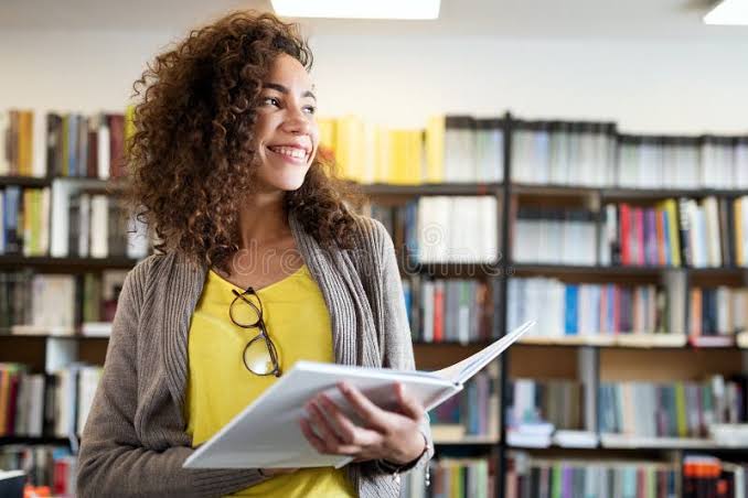Adult learner reviewing materials in a bright library