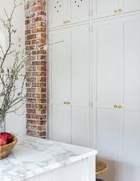 Exposed Brick Frames Floor To Ceiling White Shaker Kitchen Cabinets Accented With Antique Br Shaker Doors Kitchen Cabinets To Ceiling Floor To Ceiling Cabinets