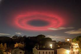 The 'Red Halo' Over Italy: Not UFOs, But a Millisecond of Science (ELVEs Explained) A captivating photograph of a massive, glowing red ring hovering over the night sky of Possagno, a small