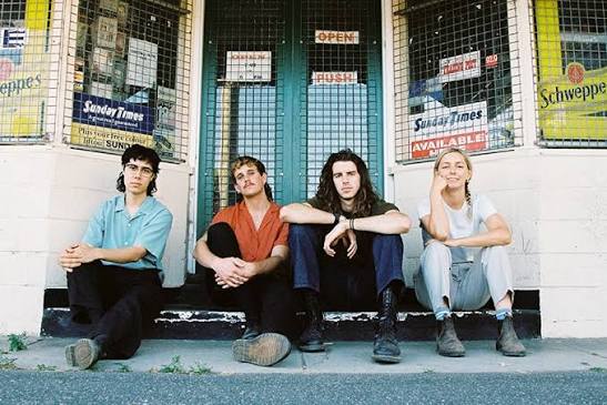 Four members of Spacey Jane sit on a stoop