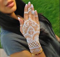 Brunette Woman In A Grey T Shirt With Long Dark Hair Holding Her Hand Up To Show Elaborate White Henna Hand Tattoo In 2020 White Henna Designs Henna Tattoo White Henna