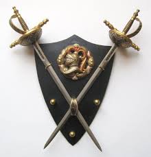 Handcrafted and carved from solid oak, this vertical sword plaque will display your sword or dagger on your wall amidst a backdrop of entwined norse serpents and a raven. Crossed Swords And Shield Miniature Toledo Wall Plaque With Damascene Decoration Wall Plaques Black Shield Miniatures