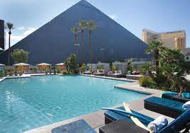 Water streams elegantly down a series of pillars and misters are located around the abundant palms. Las Vegas Pools Lounge Chairs Cabanas Luxor Hotel Casino