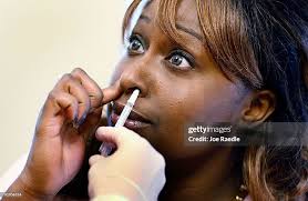Mayra Medrano receives a H1N1 nasal flu spray vaccine from medical... News  Photo
