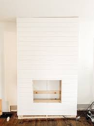 The abstract artwork over the fireplace draws the eye to the middle of the room and cohesively marries with the other colors seen throughout the space. Diy Shiplap Electric Fireplace Mantel Micheala Diane Designs