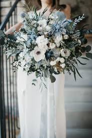 A pastel wedding bouquet of peachy and lilac blooms plus greenery is a chic and tender idea for a soft look. Bsaba Light Blue White Flower Bouquet Boho Floral Wedding Etsy White Flower Bouquet Blue Wedding Flowers Winter Wedding Flowers
