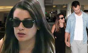 Lea Michele clings to her tall boyfriend Matthew Paetz as they land at LAX 