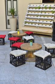 Spool Coffee Tables With Milk Crate Seats In Front Of A Herb Wall Muebles Con Cajas Muebles De Plastico Muebles Reciclados